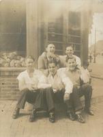 Five young men sitting outside a corner grocery store, Philadelphia.