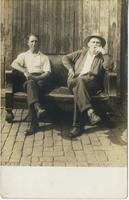 Two mature men sitting outside on a sofa, Philadelphia.