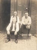 Three men sitting on a wooden stoop, Philadelphia.