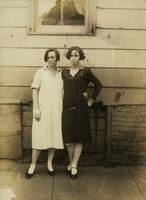 Two women standing in front of old house, Philadelphia.