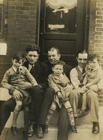 Three men, possibly fathers, with three boys, possibly their sons, sitting on marble step, Philadelphia.