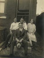 Three men and a woman on stone steps next to an alley, Philadelphia.