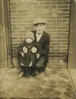 Young man and child in front of brick wall, Philadelphia.