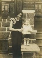 Young woman standing on porch with little boy, Philadelphia.