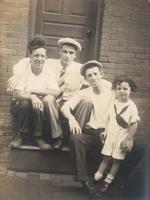 Three men and a little boy sitting on a wooden stoop, Philadelphia.