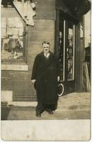 John Frank Keith standing in front of store, Philadelphia.