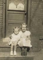 Two little girls sitting on a wooden stoop, Philadelphia.