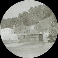 [View of canal bridge with adjacent mill building.]