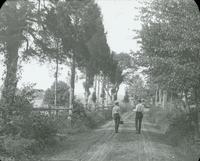 [Two men walking along a path near Wissahickon Creek.]