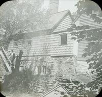 [Catharine Rupp Doering standing in front of a mill building.]