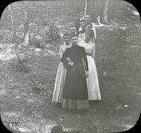 [Group portrait of unknown young persons standing in a row.]