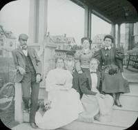 [Group portrait with Al Lindsay and Catharine Rupp Doering on porch of unidentified house.]