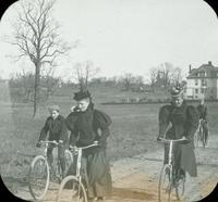 [Bicycling trip, Karl Doering and Mrs. Schwarts bicycling on dirt road.]