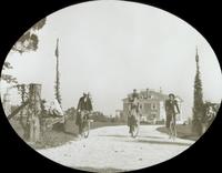 [Group bicycling along driveway of large house, Long Island, N.Y.]