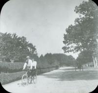 [Couple riding a tandem bicycle, Long Island, N.Y.]