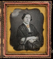 [Unidentified young woman, hands folded, wearing a square pin on her lace collar.]