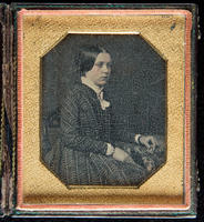 [Portrait of a seated, unidentified young woman wearing a boldly patterned dress.]