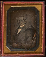 [Portrait of an unidentified man seated facing right, with his hands folded in his lap.]