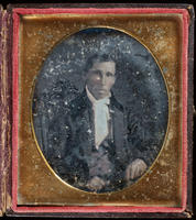 [Portrait of an unidentified, seated, unsmiling man wearing a white collar, tie, and jabot.]