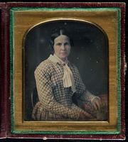 [Portrait of an unidentified woman wearing a plaid dress with a white scarf at the neck.]