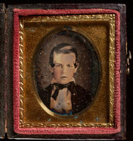 [Portrait of an unidentified, young boy, hair neatly combed, with a curl at each side.]