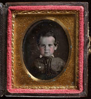 [Portrait of an unidentified, young boy, hair neatly combed, with a curl at each side.]