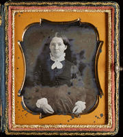[Portrait of seated, unidentified woman, hair parted in the middle, with a white lace collar and cuffs on her dress.]