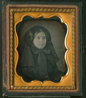 [Portrait of an unidentified, young woman dressed all in black, with a large black hat on her head tied in a big bow at the neck.]