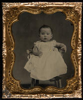 [Portrait of an unidentified baby sitting in a high chair.]