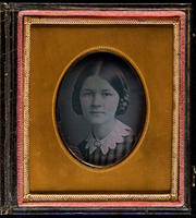 [Caroline Wood in a plaid dress with scalloped white collar and a brooch.]