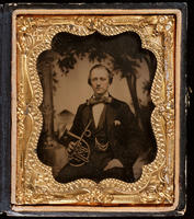 [Seated musician holding a brass horn in his right hand.]