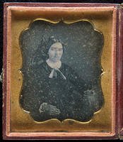 [Portrait of an unidentified woman, hair parted severly in the middle, wearing a black dress with white collar and cuffs.]