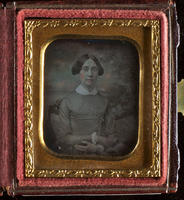 [Seated portrait of a unidentified woman, her hair parted in the middle, arms crossed on her lap, white collar at her neck.]