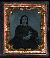 [Portait of an unidentified, young woman wearing a dark dress with a white collar, with her left arm resting on a table beside her.]