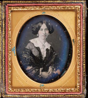 [Portrait of an unidentified young woman, hair parted in the middle, wearing a big lace collar with a cameo pin at her neck.]