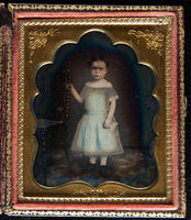 [Standing portrait of a little girl posed next to a chair.]