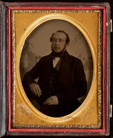 [Portrait of a balding, unidentified man with his right arm is resting on a table. ]